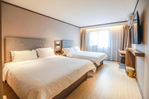 Een bed of bedden in een kamer bij Hanting Hotel Shanghai Songjiang Zuibaichi Metro Station