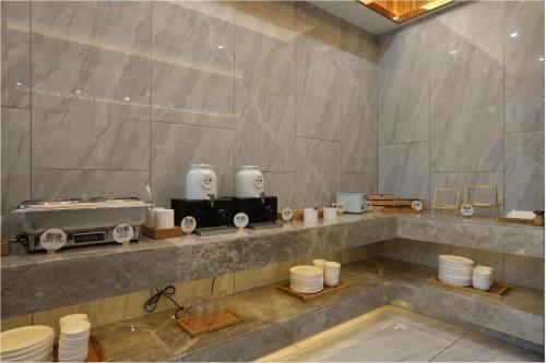 a bathroom with a counter with cups and appliances at Starway Hotel Nanchang West Lake Wanda Plaza in Taohua