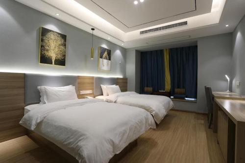 a hotel room with two beds and a sink at Starway Hotel Nanchang West Lake Wanda Plaza in Taohua