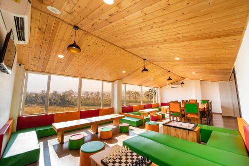a room with green and wooden furniture and windows at Lifespace Rishikesh- Hotel, Hostel, Cowork, Cafe in Rishīkesh