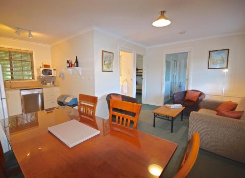 a living room with a table and chairs and a kitchen at Port Arthur Villas in Port Arthur