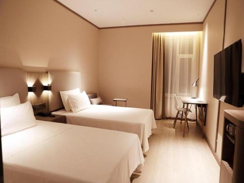 Hanting Hotel Changchun Jilin Road tesisinde bir odada yatak veya yataklar