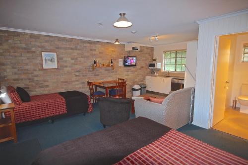 a hotel room with two beds and a living room at Port Arthur Villas in Port Arthur