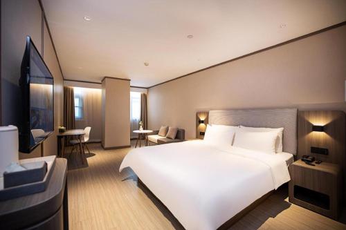 Łóżko lub łóżka w pokoju w obiekcie Hanting Hotel Jiaozuo Municipal Government