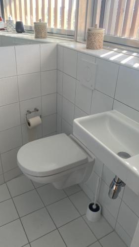 een witte badkamer met een toilet en een wastafel bij Central apartment in Kopenhagen