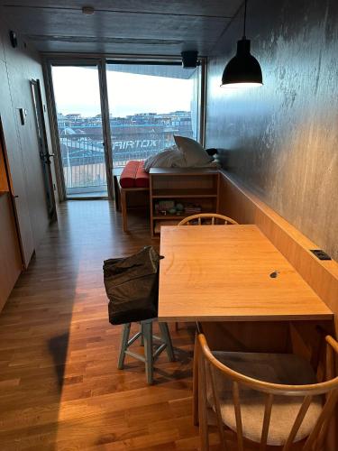 コペンハーゲンにあるCentral apartmentのテーブルとベッド、窓が備わる客室です。