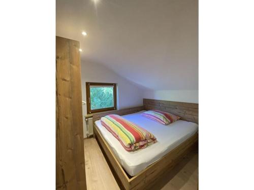 ein kleines Schlafzimmer mit einem Bett und einem Fenster in der Unterkunft Apartment with Baltic Sea view in Sautens