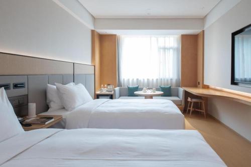 a hotel room with two beds and a window at JI Hotel Zibo Renmin West Road in Zibo