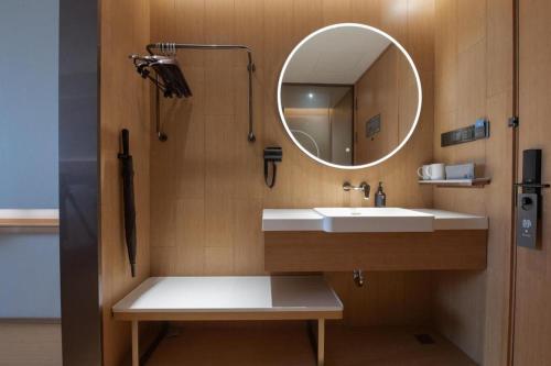 a bathroom with a sink and a mirror at JI Hotel Zibo Renmin West Road in Zibo