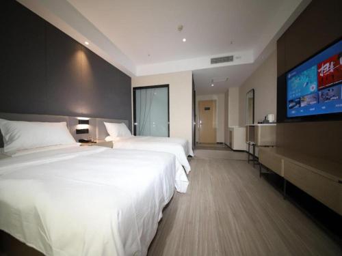 Posteľ alebo postele v izbe v ubytovaní Hanting Hotel Aksu Shanghai Road Fengquanhe