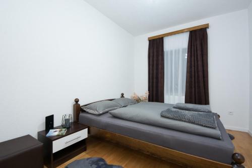 una camera con un grande letto e una finestra di GOLD Apartman a Sanski most