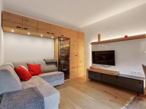 a living room with a couch and a flat screen tv at Charming Apartment in Jochberg with Balcony in Jochberg