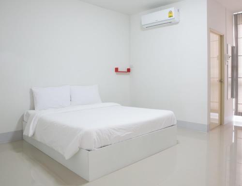 Honghub Sakon Hotel tesisinde bir odada yatak veya yataklar