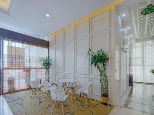 a room with a table and chairs and a wall at Vienna Hotel Hunan Liuyanghe Daqiao in Liuyang