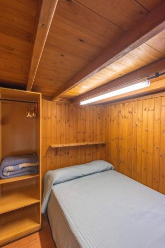 a small room with a bed in a wooden cabin at Camping Rio Purón in Llanes