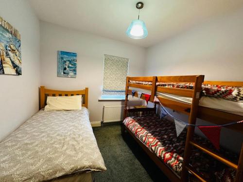 ヴァレンティア島にある7 Knightshaven Holiday Village, Valentia Islandのベッドルーム1室(二段ベッド2組、ベッド1台付)