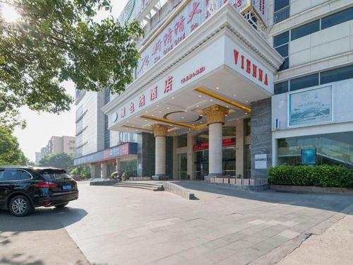 ChangleにあるVienna Hotel Fuzhou Changle Zhenghe Metro Stationの建物前に駐車する車