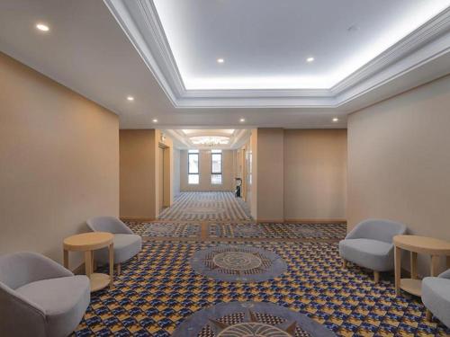 une salle d'attente avec des chaises et un plafond dans l'établissement Vienna Hotel Zhejiang Tongxiang Puyuan, à Tongxiang