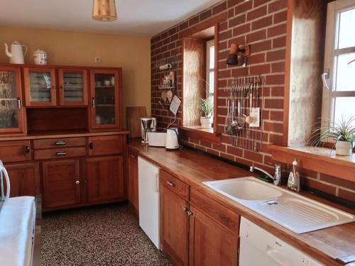 a kitchen with a sink and a brick wall at Old Town Hall apartment in Baden-Württemberg in Weilmünster