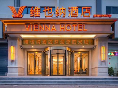 YutaiにあるVienna Hotel Tianjin Chentangzhuang Metro Stationのネオンの看板が目の前にあるヴェンナ ホテル