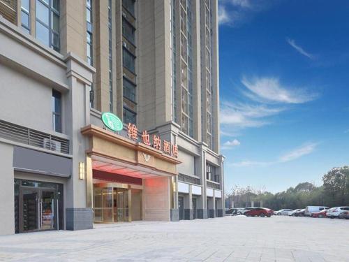 duży budynek z znakiem na boku w obiekcie Vienna Hotel Anhui Fuyang Chengnan New District w Fuyang