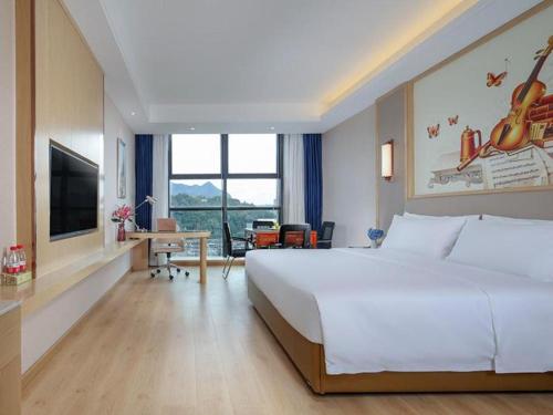 Pokój hotelowy z dużym łóżkiem i biurkiem w obiekcie Vienna Hotel Zhejiang Wenzhou Yongjia Wanchao Square w mieście Yongjia