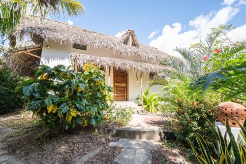 a small house with a thatch roof at TwoTen° Surf Home in Popoyo