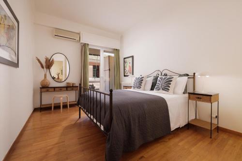 1 dormitorio con cama y espejo en Zampeli Apartment, en Corfú