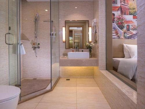 La salle de bains est pourvue d'une douche, d'un lavabo et d'une baignoire. dans l'établissement Vienna Hotel Yunnan Dali Ancient City Scenic Spot, à Vieille ville de Dali
