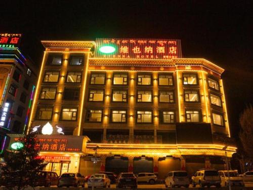 un edificio con luz verde encima en Vienna Hotel Qinghai Yushu Tangfan Avenue en Chumda