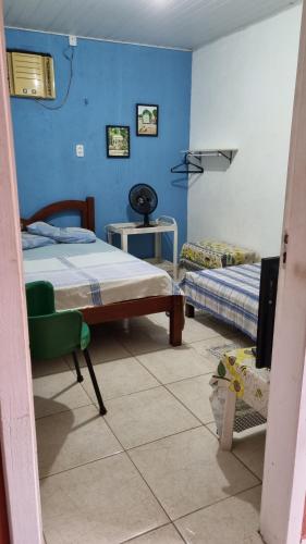 a room with two beds and a tv in it at Pousada da Didi in Belém
