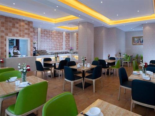um restaurante com mesas e cadeiras e um balcão em Vienna Hotel Hunan Chenzhou Municipal Government em Chenzhou