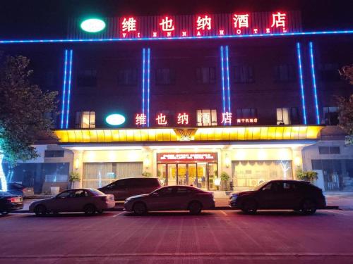 three cars parked in a parking lot in front of a building at Vienna Hotel Nanning Airport in Tanbai