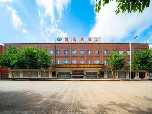 a large brick building with a sign on top of it at Vienna Hotel Nanning Airport in Tanbai