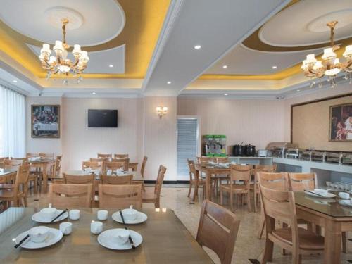 restauracja ze stołami i krzesłami oraz bar w obiekcie Vienna Hotel Shaanxi Ankang Jiangnan w mieście Kuan-miao