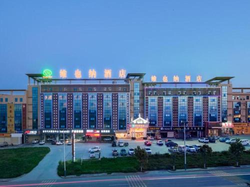 duży hotel z parkingiem przed nim w obiekcie Vienna Hotel Shaanxi Ankang Jiangnan w mieście Kuan-miao