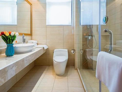 e bagno con servizi igienici, lavandino e doccia. di Vienna Hotel Taicang Zhenghe Road a Zhoujiating