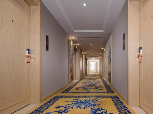 einen Flur mit einem Teppich auf dem Boden in einem Gebäude in der Unterkunft Vienna Hotel Yunnan Dali Erhai Lake in Dali