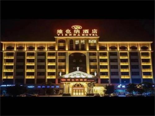 a large building with a sign on it at night at Vienna Hotel Ganzhou Economic Development Zone 1st Hospital West High-Speed Railway Station in Ganzhou