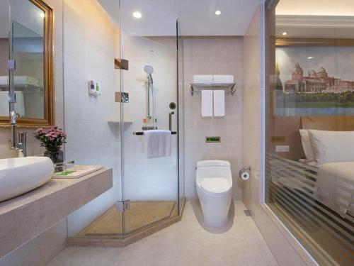 y baño con ducha, aseo y lavamanos. en Vienna Hotel Zhejiang Jinhua Jinyuhuayuan, en Chengnan