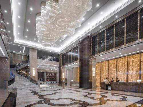 een lobby met een grote kroonluchter in een gebouw bij Venus Royal Hotel Ordos Yijinhuoluo Banner Olympic in Ordos