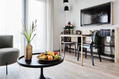 a living room with a bowl of fruit on a table at Hotel BalthazarS in Seligenstadt