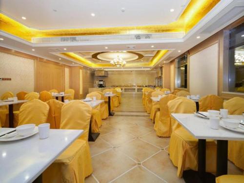 una sala da pranzo con tavoli e sedie gialle. di Vienna Hotel Guangdong Huidong Exhibition Center a Huidong