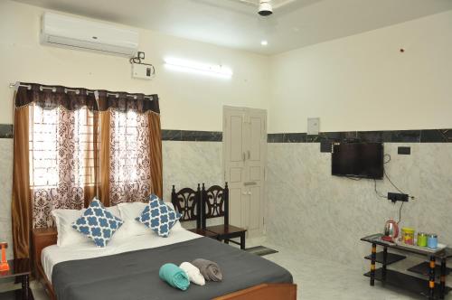 a bedroom with a bed with two towels on it at Roof-top stay in centre of city in Thanjāvūr