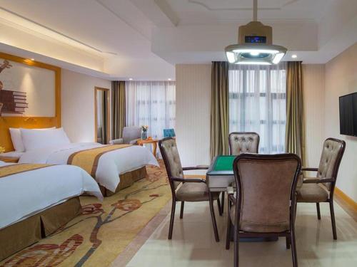 Vienna Hotel Chongqing Wanzhou Wanda Plaza في Wanxian: غرفة فندقية بسريرين وطاولة وكراسي
