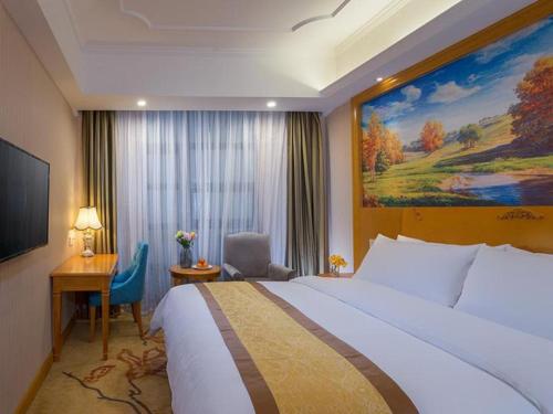 Vienna Hotel Chongqing Wanzhou Wanda Plaza في Wanxian: غرفة الفندق بسرير كبير ومكتب