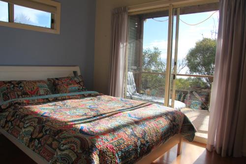 a bedroom with a bed and a large window at Emu Bay Stay in Emu Bay