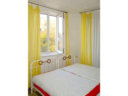 - une chambre avec un lit doté de rideaux jaunes et d'une fenêtre dans l'établissement Charming apartment in Vodice, à Ždrelac