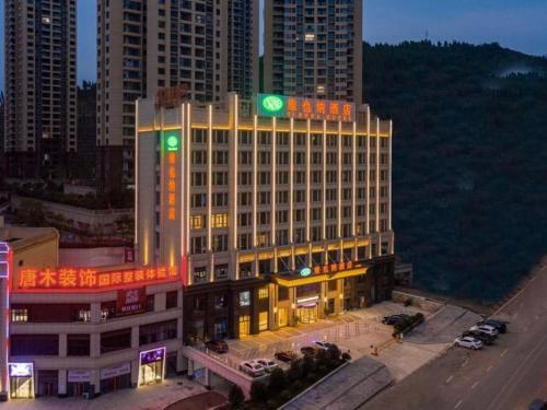 un edificio con una señal verde encima en Vienna Hotel Chongqing Fengdu, en Fengdu