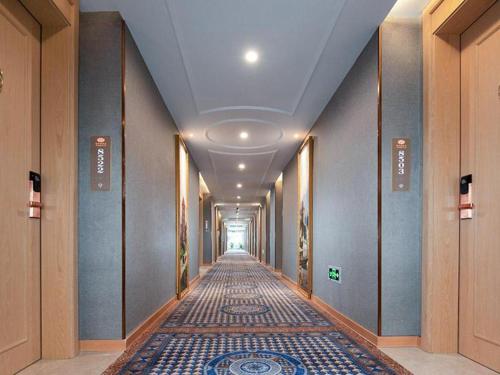 einen langen Flur mit Korridorngthngthngthngth in der Unterkunft Vienna Hotel Jiangxi Ji'an Yanjingfu in Ji'an